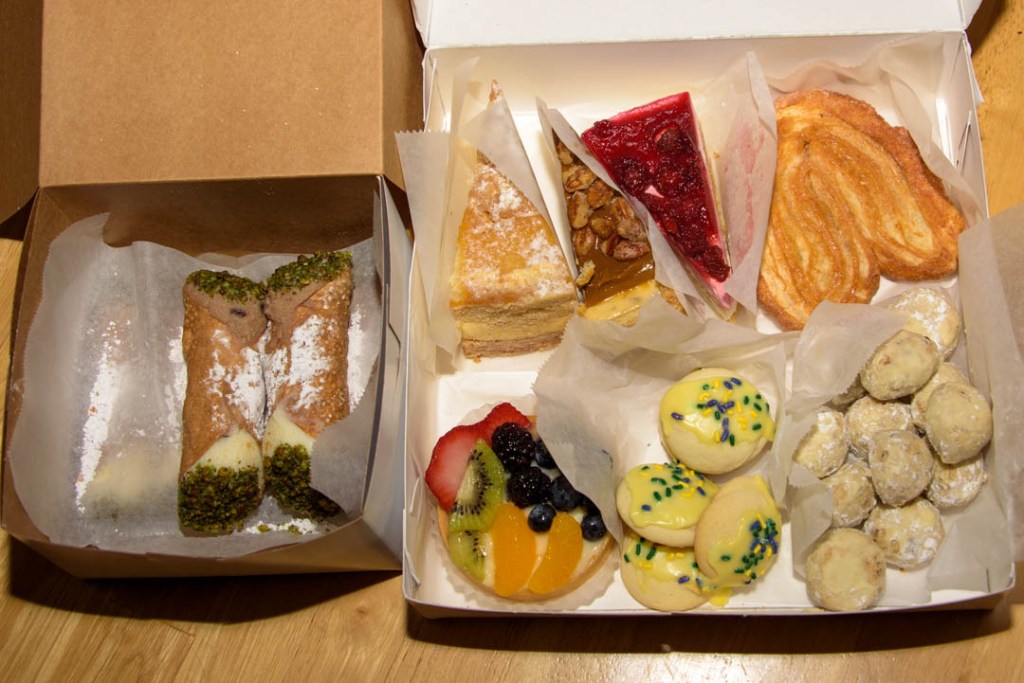 Image of two bakery boxes filled with assorted Italian pastries, including fresh cannoli, from Angelo Brocato in New Orleans.