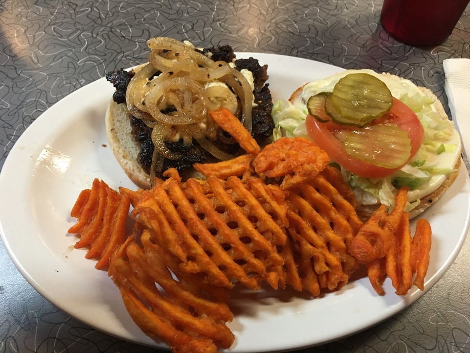 Image of white plate with open-face hamburger, fried onions, and waffle sweet potato fries, taken at Clover Grill in New Orleans.