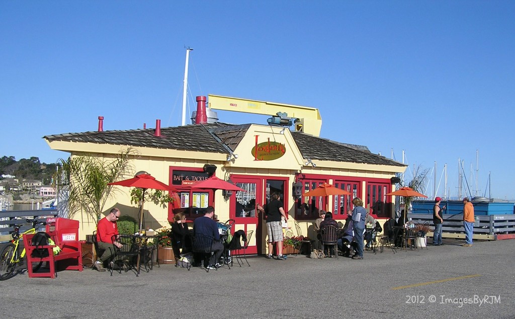 Customers seated at tables outside LouLou's Griddle in the Middle, on Monterey Bay's commercial wharf, 